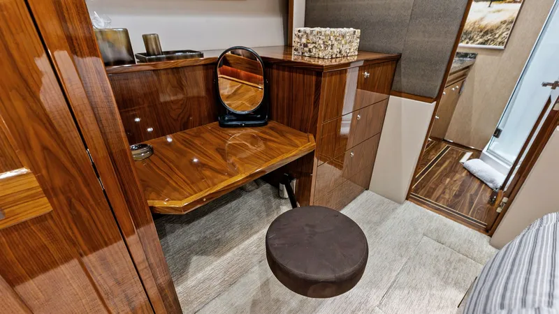 Slide: The Image of Elegant Vanity Area with Seating This stylish vanity area features a sleek, high-gloss wood finish complemented by a comfortable round stool. The neatly integrated mirror and ample drawer storage enhance both functionality and elegance. Soft lighting and refined materials make this a sop - 7932665