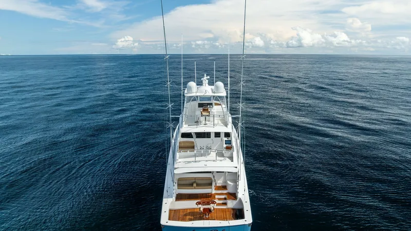 Slide: The Image of Aft Deck and Flybridge Overview This image showcases the expansive aft deck and flybridge of the 2017 Viking 80 Convertible, 'Aussie Rules'. The aft deck features elegant teak flooring with ample seating, ideal for leisure or entertaining. Above, the flybridge offers a commanding view, - 7932721