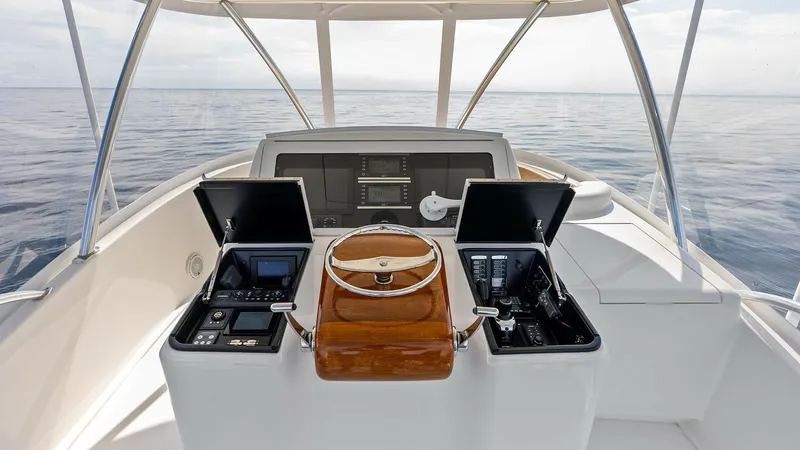 Slide: The Image of Flybridge Helm Station The helm station of the 2017 Viking 80 Convertible 'Aussie Rules' offers a commanding view with state-of-the-art navigation systems. Featuring a polished wooden steering wheel and dual electronics compartments, the design maximizes functionality and style - 7932645