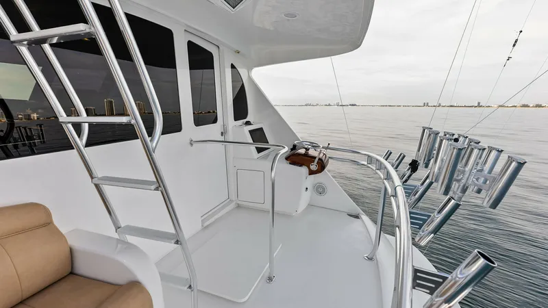 Slide: The Image of Flybridge Aft with Rod Holders The flybridge aft of the 2017 Viking 80 Convertible 'Aussie Rules' showcases an angler-friendly setup with multiple rod holders. The spacious area features a comfortable seating arrangement and a sleek ladder leading to the upper helm. Enjoy panoramic vie - 7932685