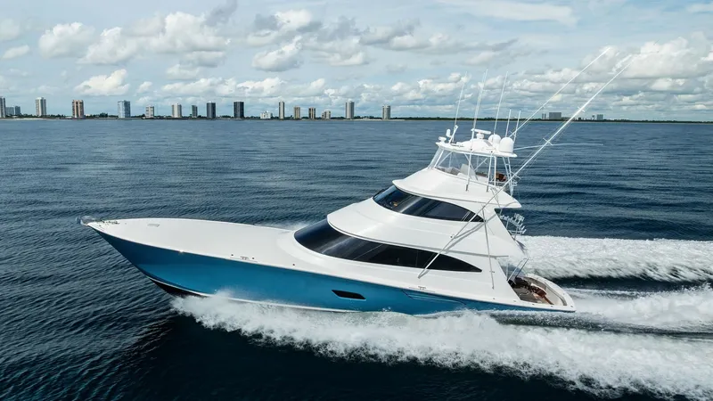 Slide: The Image of Aerial View of Viking 80 Convertible This striking image showcases the sleek profile of the 2017 Viking 80 Convertible, 'Aussie Rules', cutting through the water with ease. The yacht's modern design features a striking blue hull and expansive, tinted windows that enhance its aerodynamic appe - 7932725