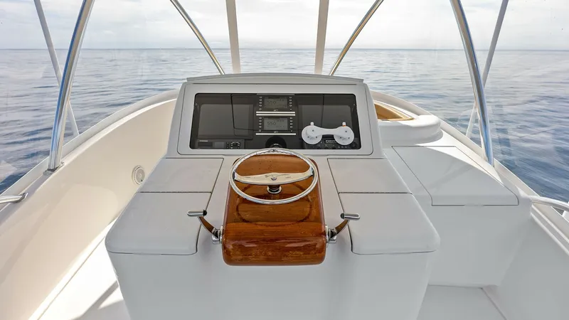 Slide: The Image of Flybridge Helm Station The helm station of the Viking 80 Convertible offers a commanding view with state-of-the-art navigation equipment. The sleek design features a polished wooden steering wheel, integrated with modern controls and dual screens for optimal functionality. This - 7932688