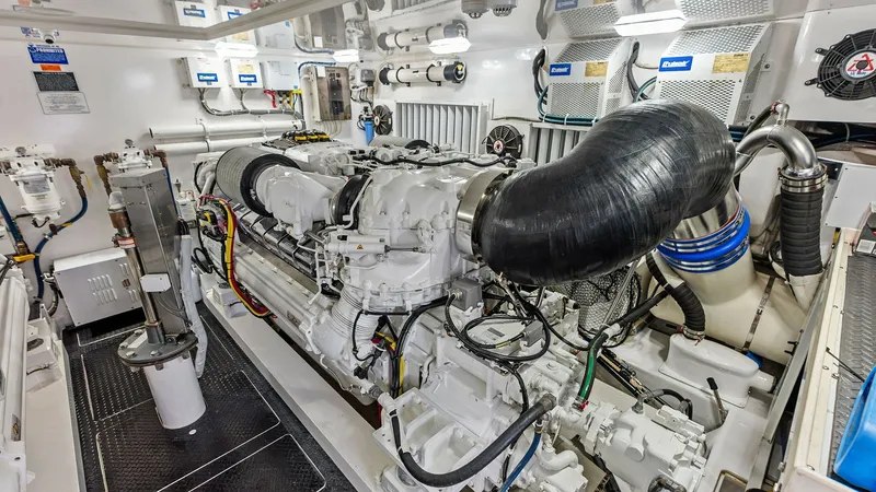 Slide: The Image of Engine Room with Twin Engines The engine room of the 2017 Viking 80 Convertible 'Aussie Rules' showcases its twin engines, meticulously maintained and housed in a pristine environment. The space is well-organized, with clearly labeled systems and high-quality components ensuring optim - 7932704