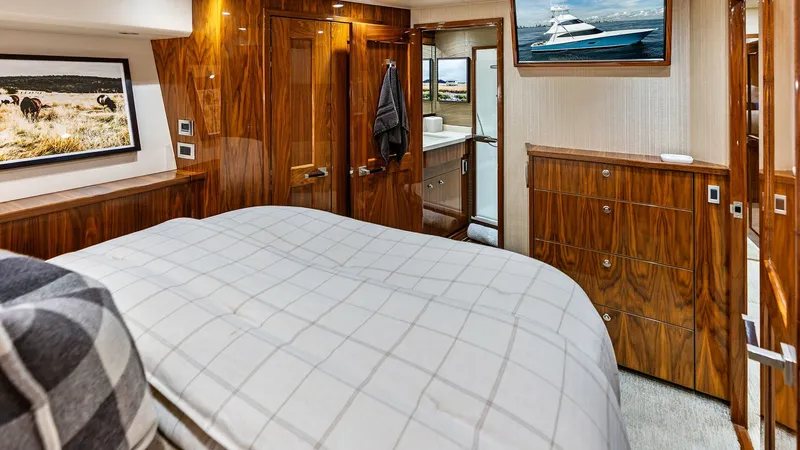 Slide: The Image of Luxurious Master Stateroom The master stateroom of the 2017 Viking 80 Convertible, 'Aussie Rules', offers a spacious and elegantly designed retreat. Rich wood finishes and ambient lighting create a warm and inviting atmosphere. The room features ample storage, a plush bed, and a pr - 7932669