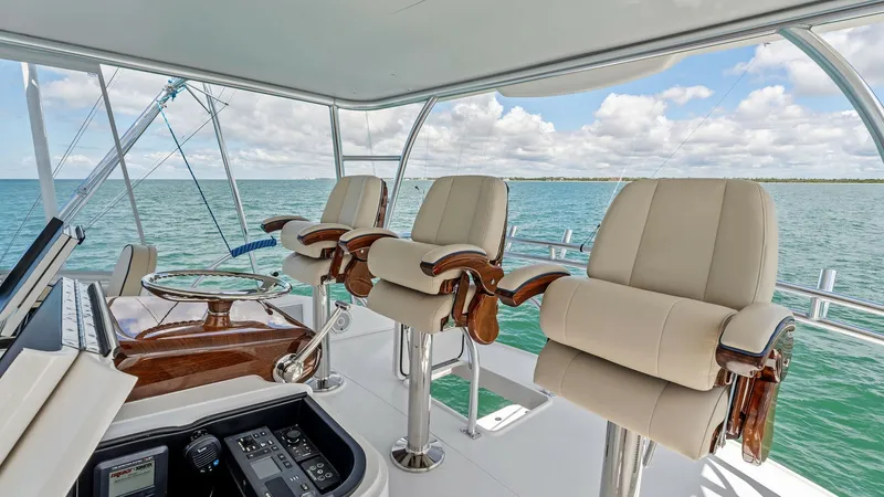 Slide: The Image of Flybridge Helm with Captain Chairs The flybridge of the 2024 Viking 68 Convertible 'Laid Back' features a sleek helm station equipped with advanced navigation controls for optimal performance. Three luxurious captain chairs offer comfort and style, with panoramic ocean views enhancing the - 7933118