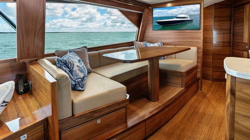 Slide: The Image of Salon Dining Area with Ocean View This inviting salon dining area on the 2024 Viking 68 Convertible features rich wood finishes and plush seating, creating a warm and elegant atmosphere. Large windows offer breathtaking ocean views, enhancing the sense of openness and connection to the se - 7933130