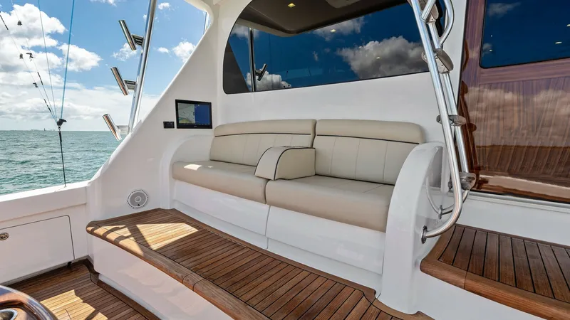 Slide: The Image of Aft Deck Seating Area This inviting aft deck of the 2024 Viking 68 Convertible features plush, cream-colored seating perfect for relaxation and enjoying sea views. The teak flooring adds a touch of elegance, contrasting beautifully with the sleek white exterior. Ample natural - 7933160