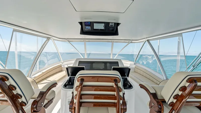 Slide: The Image of Flybridge Helm Station with Seating The flybridge helm station of the 2024 Viking 68 Convertible features state-of-the-art navigation equipment and a commanding view of the surroundings. Luxurious, cushioned seating with polished wood accents provides comfort and style, while the expansive - 7933161