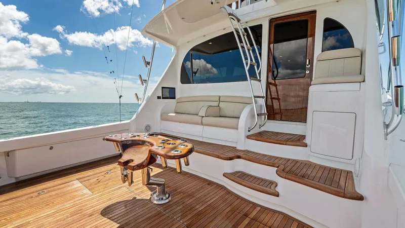 Slide: The Image of Teak Aft Deck with Seating Area Experience luxury on the Viking 68 Convertible's aft deck, featuring elegant teak flooring and a comfortable seating area. The built-in bench provides a perfect spot to relax and enjoy the ocean views. Designed for both leisure and functionality, this spa - 7933155