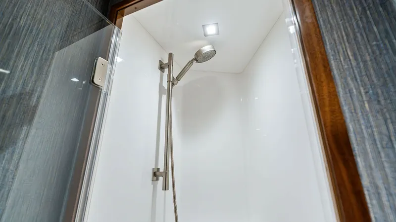 Slide: The Image of Modern Yacht Shower Enclosure This sleek shower enclosure on the 2024 Viking 68 Convertible features a contemporary design with high-quality fixtures. The spacious interior is highlighted by a stylish handheld showerhead and a bright overhead light, creating a luxurious and refreshing - 7933140