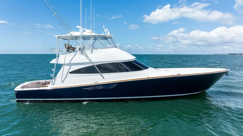 Slide: The Image of Starboard Profile of Viking 68 Convertible The 2024 Viking 68 Convertible showcases a sleek and powerful starboard profile against a beautiful ocean backdrop. Its modern design features a striking dark hull with a contrasting white superstructure, enhancing its elegant and aerodynamic lines. The s - 7933168