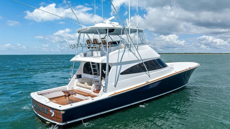 Slide: The Image of Aft Deck and Flybridge View This image showcases the sleek design of the 2024 Viking 68 Convertible's aft deck and flybridge. The spacious aft deck features a beautifully finished teak floor, ideal for fishing or relaxation. Above, the flybridge offers a commanding view, equipped wi - 7933174