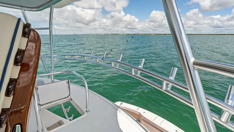 Slide: The Image of Flybridge with Helm Seating This image showcases the flybridge of the 2024 Viking 68 Convertible, featuring a comfortable helm seating area with a polished wood finish. The sleek stainless steel railings provide safety and style, while offering unobstructed panoramic views of the wa - 7933167