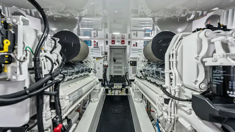 Slide: The Image of Engine Room with Twin Engines The engine room of the 2024 Viking 68 Convertible showcases powerful twin engines, meticulously arranged for optimal performance. The space is well-organized with high-quality components and accessible pathways for maintenance. The clean, bright environme - 7933152