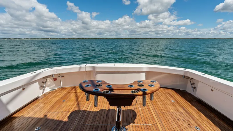 Slide: The Image of Spacious Aft Deck with Rod Holders The aft deck of the 2024 Viking 68 Convertible, 'Laid Back', features a beautifully crafted teak finish, complemented by a central fishing station equipped with multiple rod holders. This open area provides ample space for fishing enthusiasts, with panora - 7933158