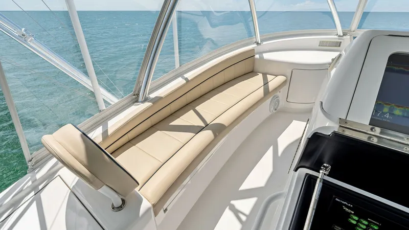Slide: The Image of Flybridge Seating Area The flybridge of the 2024 Viking 68 Convertible offers a luxurious seating area with plush, cream-colored cushions. The space is surrounded by panoramic windows, providing breathtaking ocean views and ample natural light. This inviting area is perfect for - 7933165