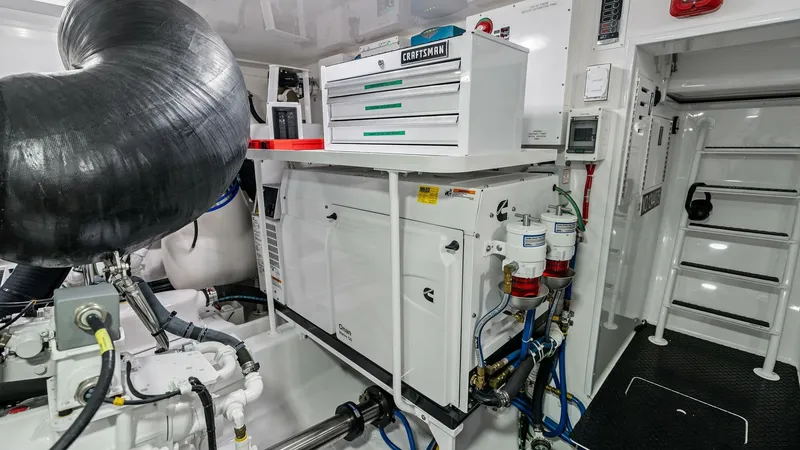 Slide: The Image of Engine Room and Equipment The engine room of the 2024 Viking 68 Convertible showcases a meticulously organized space, featuring advanced machinery and equipment. A Craftsman tool chest is prominently situated for easy access, ensuring maintenance efficiency. The area is well-lit, - 7933154
