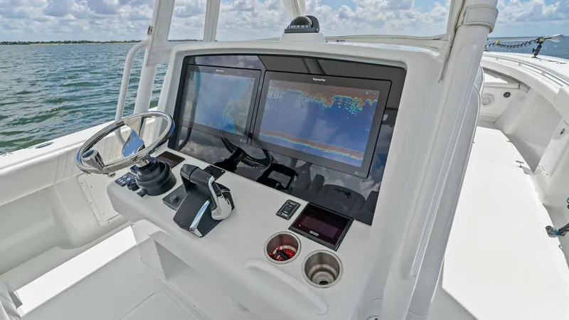Slide: The Image of Helm Station with Dual Displays This helm station on the 2014 Yellowfin 39 Center Console features dual high-resolution displays for seamless navigation and control. The sleek steering wheel and modern throttle controls provide a sophisticated driving experience. The clean, ergonomic la - 7943325