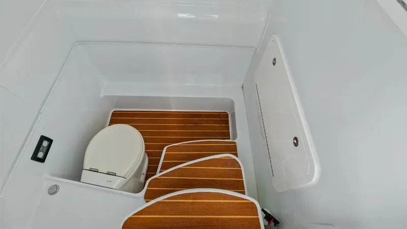 Slide: The Image of Compact Marine Head with Teak Steps This image showcases the well-designed marine head of the 2014 Yellowfin 39 Center Console. The space features a practical layout with elegant teak steps leading to the toilet area, providing both functionality and style. The clean lines and efficient use - 7943341