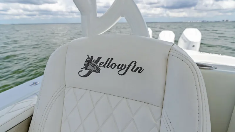Slide: The Image of Helm Seating with Logo Embroidery The helm seating of the 2014 Yellowfin 39 Center Console features luxurious white upholstery with diamond stitching. The prominent Yellowfin logo is elegantly embroidered on the seat back, showcasing brand prestige. The seating is designed for comfort and - 7943322