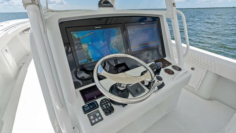 Slide: The Image of Helm Station with Dual Displays The helm station of this 2014 Yellowfin 39 Center Console features dual multifunction displays, providing comprehensive navigation and system control. The sleek, ergonomic design includes a polished stainless-steel steering wheel and conveniently placed c - 7943324