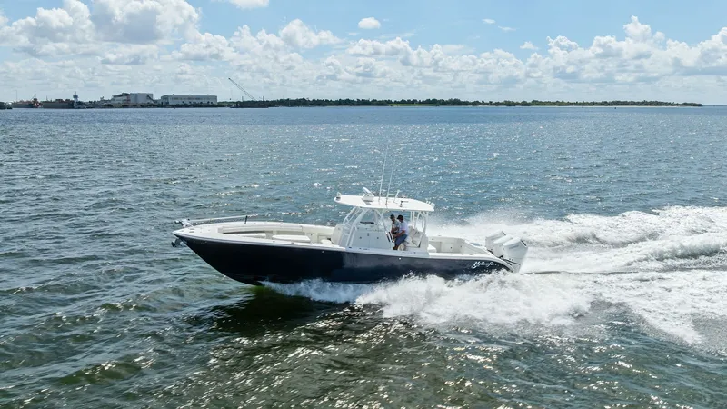 Slide: The Image of Dynamic Side View on the Water This 2014 Yellowfin 39 Center Console is captured gliding effortlessly across the water, showcasing its sleek hull design and powerful outboard engines. The image highlights the boat's sturdy T-top and spacious deck, ideal for both fishing and leisure. Th - 7943344