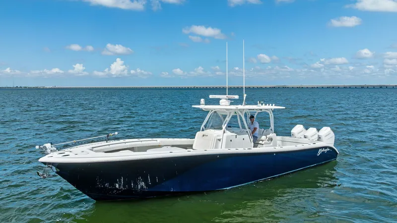 Slide: The Image of Side View of Yellowfin 39 Center Console This 2014 Yellowfin 39 Center Console showcases its sleek hull design and spacious deck, ideal for both fishing and cruising. The deep blue exterior contrasts beautifully with the white accents, highlighting its modern and sporty aesthetic. Equipped with - 7943347
