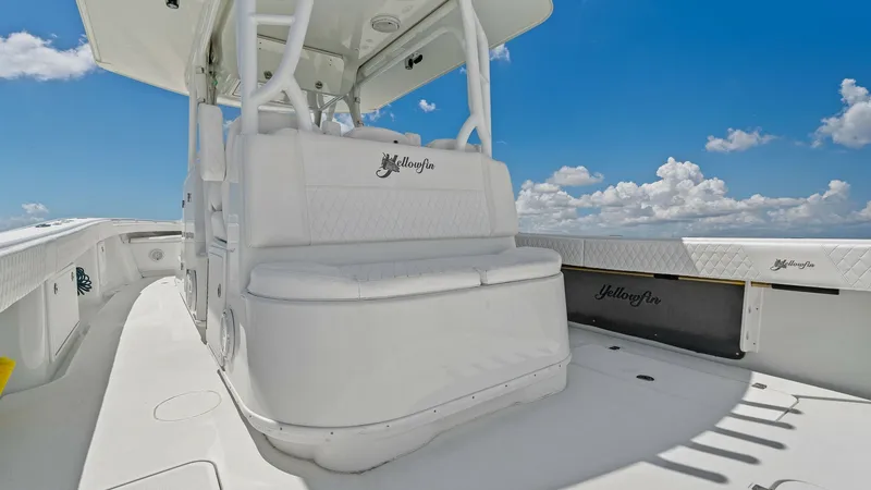 Slide: The Image of Helm Seating and T-Top This image showcases the helm seating area of the Yellowfin 39 Center Console, featuring plush, diamond-stitched upholstery for comfort and style. The robust T-top provides ample shade and integrates lighting, enhancing the vessel's functionality. Clean l - 7943313