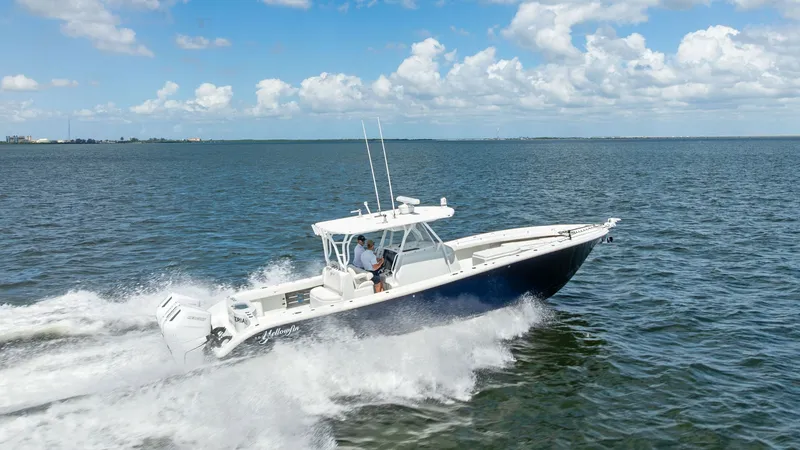 Slide: The Image of Side View of Yellowfin 39 in Motion The 2014 Yellowfin 39 Center Console is captured cruising effortlessly across open waters, showcasing its sleek hull design and powerful outboard engines. The spacious deck layout is ideal for both fishing and leisure, while the T-top provides ample shade - 7943360