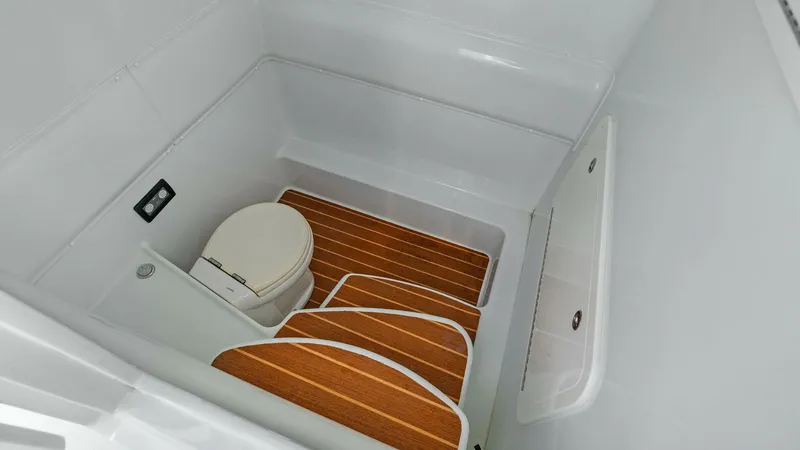 Slide: The Image of Spacious Head Compartment This 2014 Yellowfin 39 Center Console features a well-designed head compartment, showcasing a modern marine toilet and elegant teak flooring. The space is efficiently utilized, providing comfort and functionality with easy access and clean, smooth surface - 7943342