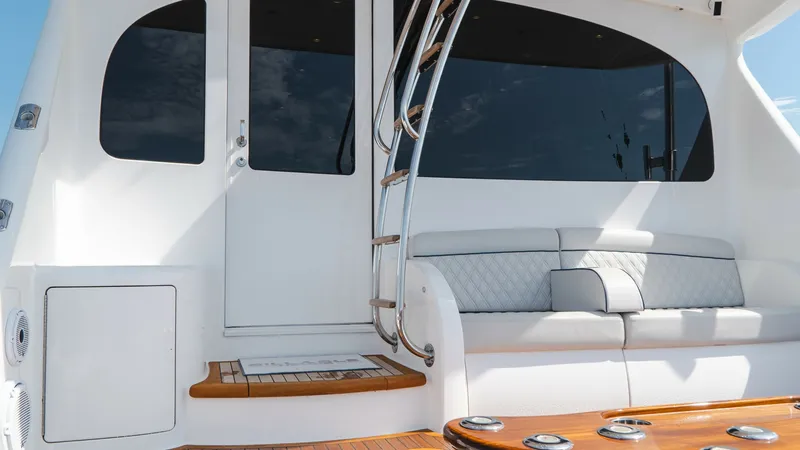Slide: The Image of Aft Deck Seating and Entryway The aft deck of the Viking 66 Convertible features a comfortable seating area with plush cushions, perfect for relaxation and entertaining. The elegant teak flooring complements the sophisticated design, while the sleek ladder provides access to the upper - 7943391