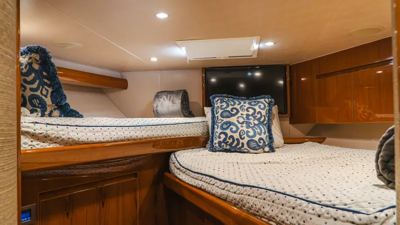Slide: The Image of Guest Stateroom with Twin Beds This cozy guest stateroom features twin beds adorned with plush, patterned bedding and accent pillows. The warm wood finishes and ample overhead lighting create an inviting and comfortable space. A flat-screen TV adds entertainment value, making this an i - 7943378