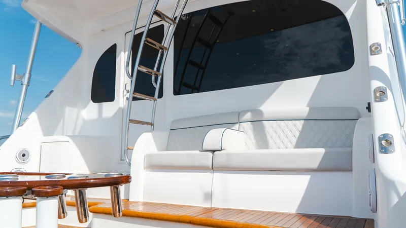 Slide: The Image of Aft Deck Seating and Ladder The aft deck of the 2014 Viking 66 Convertible features elegant seating with plush, diamond-stitched upholstery, offering comfort and style. The polished teak accents and stainless steel ladder leading to the flybridge add a touch of sophistication. This - 7943390