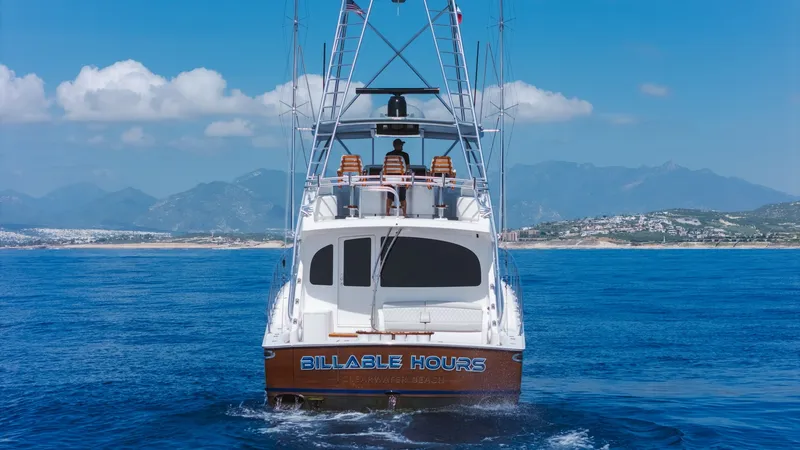 Slide: The Image of Aft View with Tower and Seating This image showcases the aft view of the 2014 Viking 66 Convertible yacht, 'Billable Hours'. The vessel features a spacious cockpit with comfortable seating, perfect for leisure or fishing activities. The towering flybridge offers an elevated vantage poin - 7943414