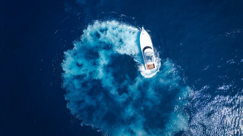 Slide: The Image of Aerial View of Vessel Maneuvering This striking aerial shot captures the 2014 Viking 66 Convertible, Billable Hours, executing a dynamic turn in open waters. The vessel's sleek profile and powerful engines create a mesmerizing swirl of ocean currents, showcasing its impressive handling ca - 7943413