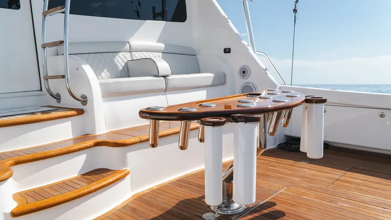 Slide: The Image of Teak Cockpit with Fishing Station The cockpit of the Viking 66 Convertible showcases a beautifully crafted teak deck with an integrated fishing station. This area features a sleek, custom-designed table with multiple rod holders, perfect for avid anglers. The comfortable seating with plus - 7943388