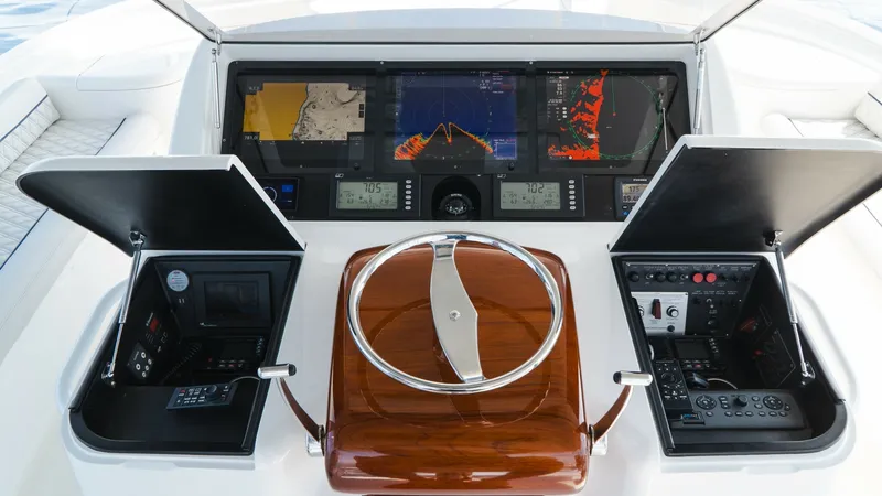 Slide: The Image of Helm Station with Electronics The helm station on the 2014 Viking 66 Convertible 'Billable Hours' features a sleek, modern design with advanced navigation systems. The polished wood steering wheel complements the dual display panels, offering comprehensive control and monitoring. This - 7943397