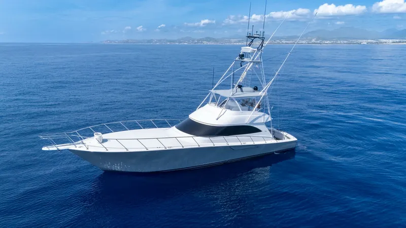 Slide: The Image of Profile View of Viking 66 Convertible This image showcases the sleek and powerful profile of the 2014 Viking 66 Convertible, named 'Billable Hours'. The yacht features a distinctive flybridge with a tuna tower, offering excellent visibility and control. Its elegant lines and robust constructi - 7943409