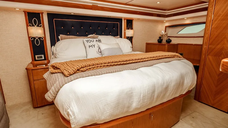 Slide: The Image of 2014 Viking 76 Enclosed Bridge "TRANQUILO" Master Stateroom This elegant master stateroom features a large, plush bed with a stylish upholstered headboard, creating a cozy yet sophisticated ambiance. The warm wood finishes and soft lighting add a touch of luxury and comfort, perfect for restful nights at sea. Ampl - 7962476
