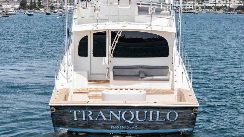 Slide: The Image of 2014 Viking 76 Enclosed Bridge "TRANQUILO" The aft view of the 2014 Viking 76 Enclosed Bridge Sportfisher, TRANQUILO, showcases a spacious cockpit designed for both relaxation and functionality. The seating area provides ample comfort for guests, while the open deck offers versatility for fishing - 7962521