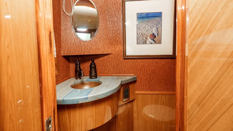 Slide: The Image of 2014 Viking 76 Enclosed Bridge "TRANQUILO" This stylish guest head on the Viking 76 Enclosed Bridge Sportfisher features a beautifully crafted vanity with a curved marble countertop and modern fixtures. The warm wooden finishes and textured wall coverings create a cozy yet sophisticated atmosphere - 7962466