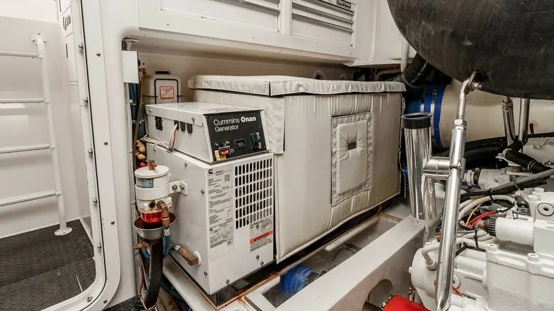 Slide: The Image of 2014 Viking 76 Enclosed Bridge "TRANQUILO" This image showcases the engine room of the 2014 Viking 76 Enclosed Bridge Sportfisher, featuring a Cummins Onan generator. The space is well-organized, with neatly arranged components and efficient use of space for easy access and maintenance. The area i - 7962501