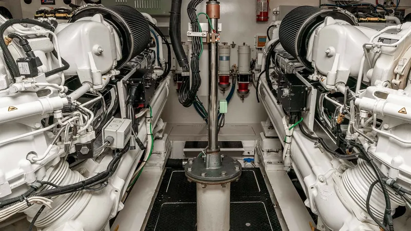 Slide: The Image of 2014 Viking 76 Enclosed Bridge "TRANQUILO" The engine room of the 2014 Viking 76 Enclosed Bridge Sportfisher, TRANQUILO, showcases twin powerful engines, meticulously arranged for optimal performance and maintenance access. The pristine white finish and organized layout highlight the vessel's comm - 7962499