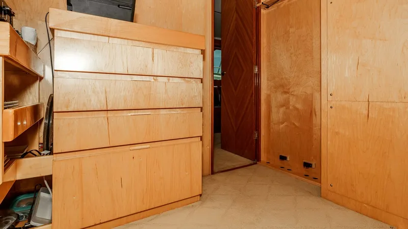 Slide: The Image of 2014 Viking 76 Enclosed Bridge "TRANQUILO" Lower Deck Companionway & Storage This image showcases the well-organized pantry storage area aboard the 2014 Viking 76 Enclosed Bridge Sportfisher, TRANQUILO. The space is efficiently utilized with multiple shelves and drawers for easy access to provisions and essential items. The light - 7962475