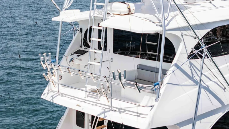 Slide: The Image of 2014 Viking 76 Enclosed Bridge "TRANQUILO" The aft deck of the 2014 Viking 76 Enclosed Bridge Sportfisher showcases a well-equipped fishing area with multiple rod holders. The space is designed for avid anglers, featuring a robust railing system and easy access to the water. The clean, white finis - 7962514