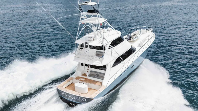 Slide: The Image of 2014 Viking 76 Enclosed Bridge "TRANQUILO" This image showcases the aft deck and enclosed bridge of the 2014 Viking 76 Enclosed Bridge Sportfisher, TRANQUILO. The spacious aft deck is designed for both relaxation and sportfishing, featuring ample seating and a sleek, uncluttered design. The enclos - 7962528