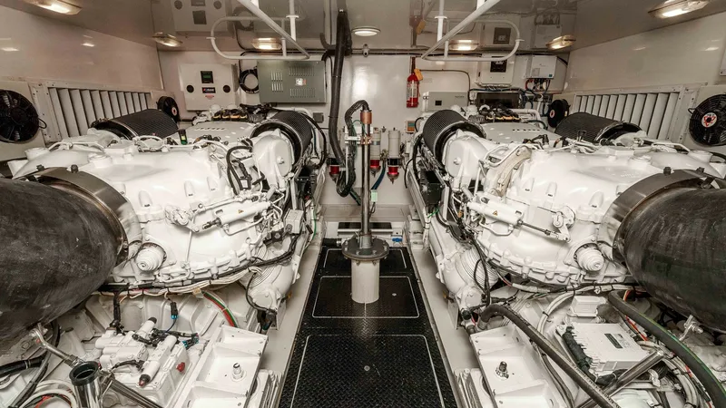 Slide: The Image of 2014 Viking 76 Enclosed Bridge "TRANQUILO" The engine room of the 2014 Viking 76 Enclosed Bridge Sportfisher showcases dual, powerful engines meticulously organized for optimal performance. The space is well-lit, highlighting the pristine condition and efficient layout of the mechanical systems. S - 7962496