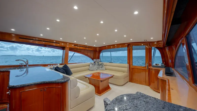 Slide: The Image of Elegant Interior Salon with Ocean Views The salon of the 2008 Blue Angel by Winter Custom Yachts offers a luxurious and inviting space with panoramic ocean views. The plush L-shaped seating surrounds a polished wooden coffee table, complemented by rich wood finishes and sleek granite countertop - 7961707
