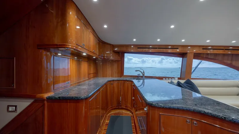 Slide: The Image of Luxurious Galley with Ocean Views This elegant galley on the Blue Angel showcases rich wood cabinetry paired with sleek granite countertops, offering both style and functionality. The expansive windows provide stunning ocean views, enhancing the open and airy feel of the space. Recessed l - 7961711