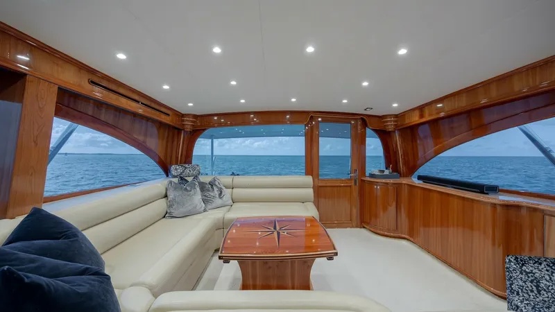 Slide: The Image of Spacious Salon with Ocean Views The salon of the 2008 Winter Custom Yachts 62 Sportfish, Blue Angel, offers a luxurious and inviting space with ample seating. Rich wood finishes and large panoramic windows provide stunning ocean views and a warm ambiance. The elegant coffee table and pl - 7961705